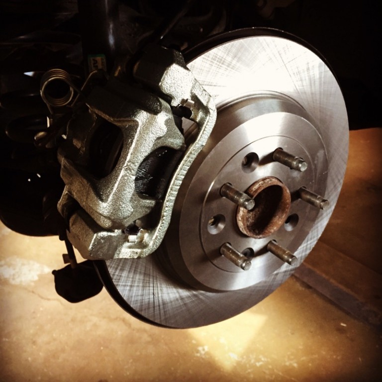 New brake rotor and caliper installed on a vehicle.