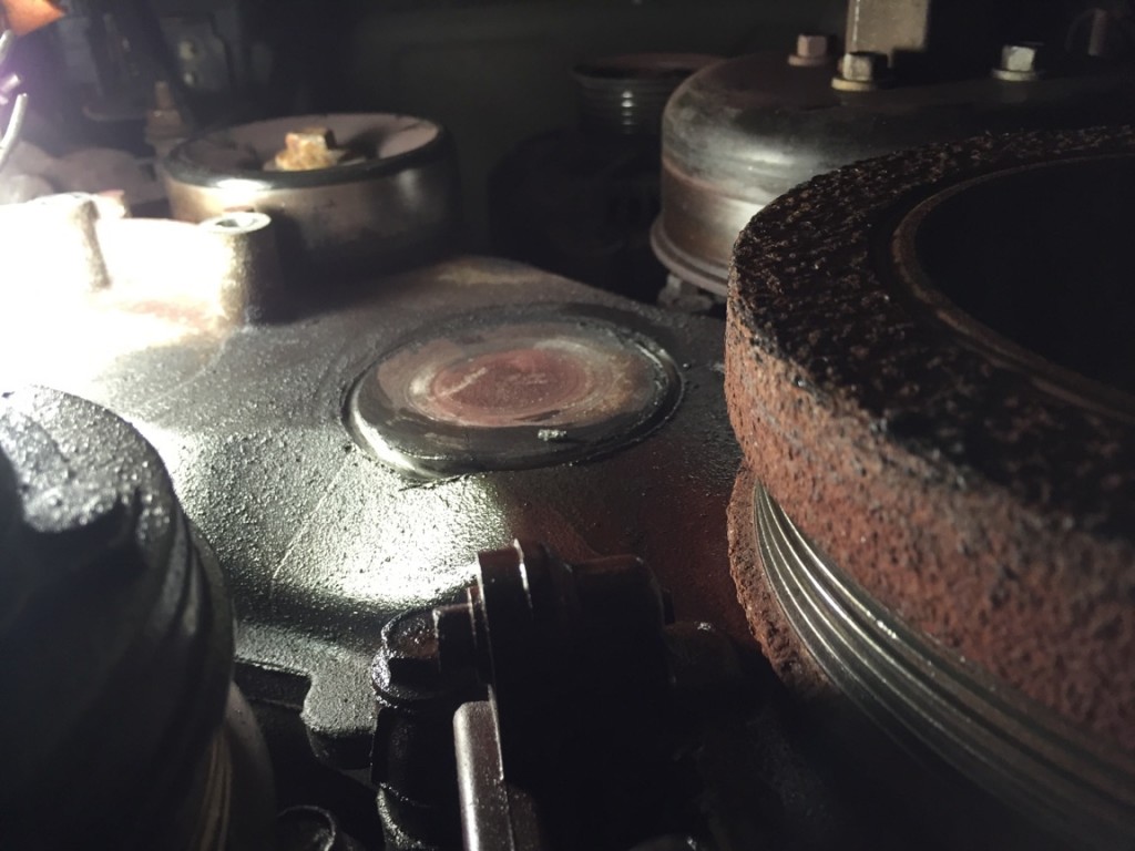 Close-up of engine pulleys and belts with service light shining in.